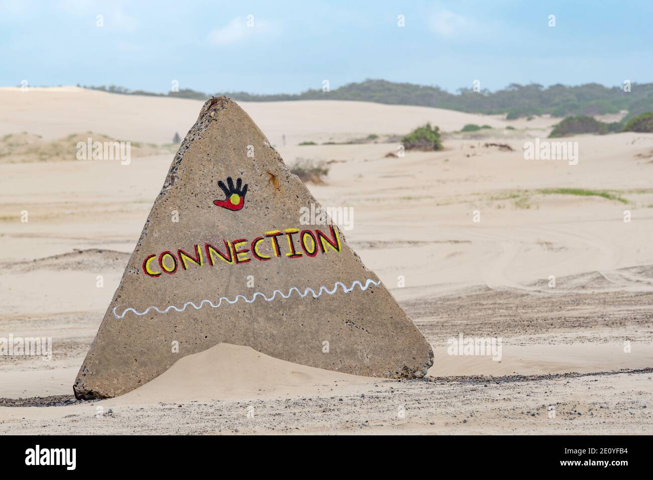 Le barriere in cemento a forma di piramide per tenere le auto fuori dalle dune di sabbia a Birubi Beach a Port Stephens, NSW, Australia sono dipinte con messaggi indigeni Foto Stock