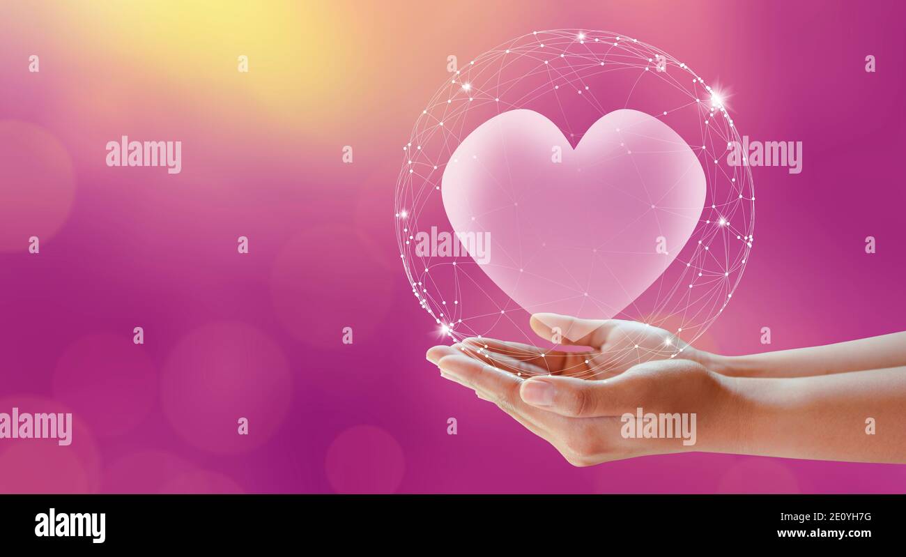Le mani della donna danno il cuore. Sfondo rosa. Amore e concetto di San Valentino. Foto Stock