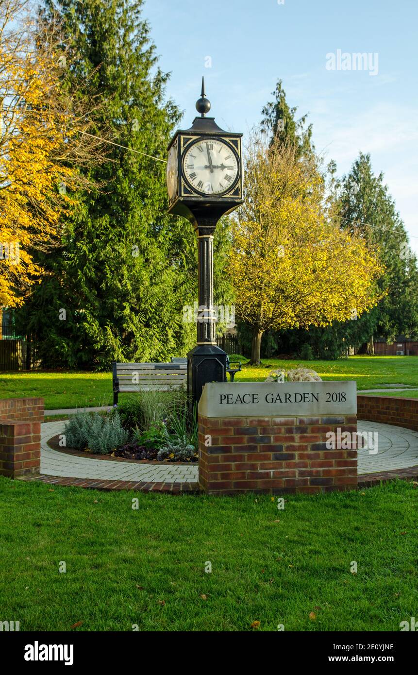 Vista del punto di riferimento orologio e Peace Garden nel centro di Bourne End nel Buckinghamshire in un sole giornata autunnale alle 3. Foto Stock