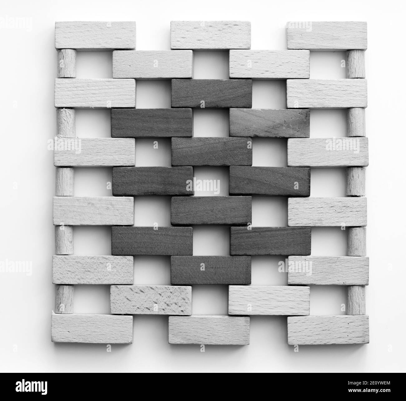 Muro fatto di piccoli mattoni di legno. Blocchi di legno bianco e nero che assomigliano a una parete di mattoni su sfondo bianco. Texture. Sfondo. Foto Stock