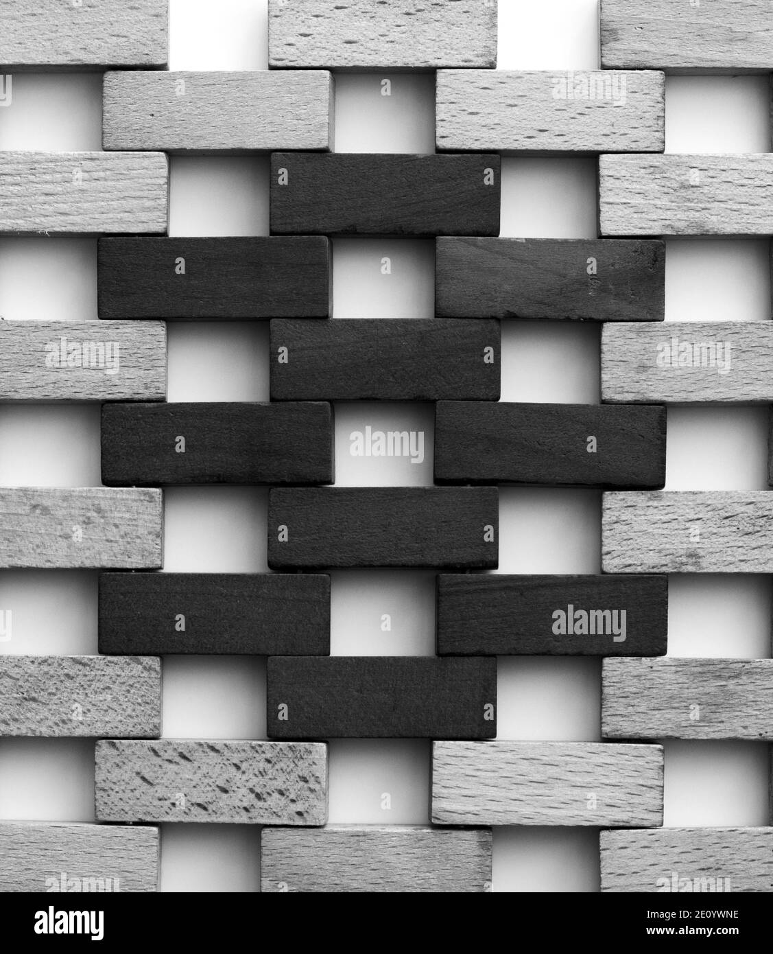 Muro fatto di piccoli mattoni di legno. Blocchi di legno bianco e nero che assomigliano a una parete di mattoni su sfondo bianco. Texture. Sfondo. Foto Stock