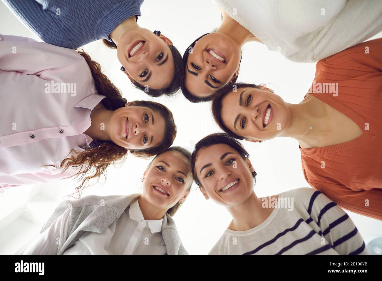Gruppo di belle donne felici che si levano insieme in cerchio e. sorridendo alla macchina fotografica Foto Stock