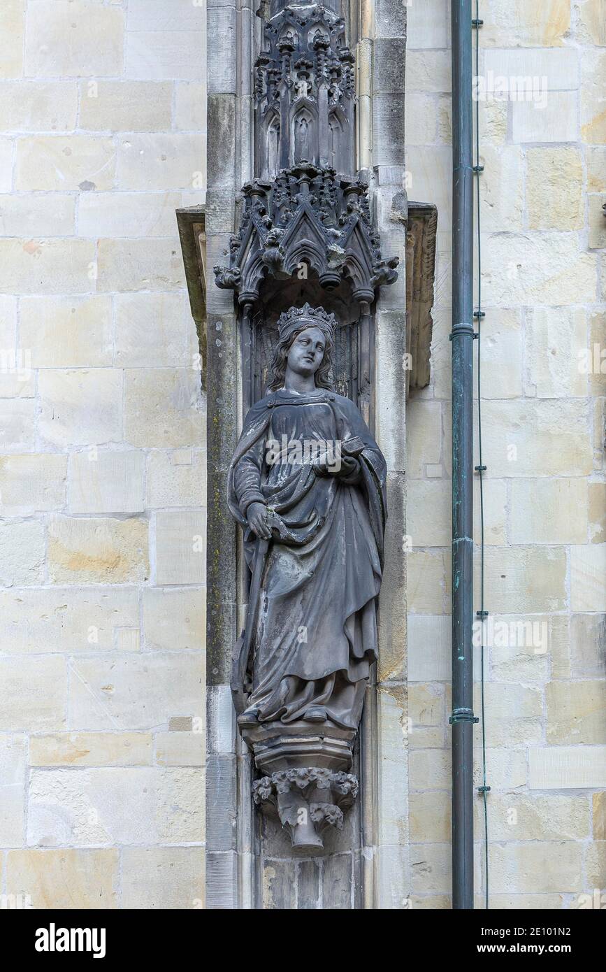 Martire Caterina d'Alessandria con ruota, spada e libro, figura sulla facciata della chiesa della Lambertikirche, Münster, Nord Reno-Westfalia, Germania Foto Stock