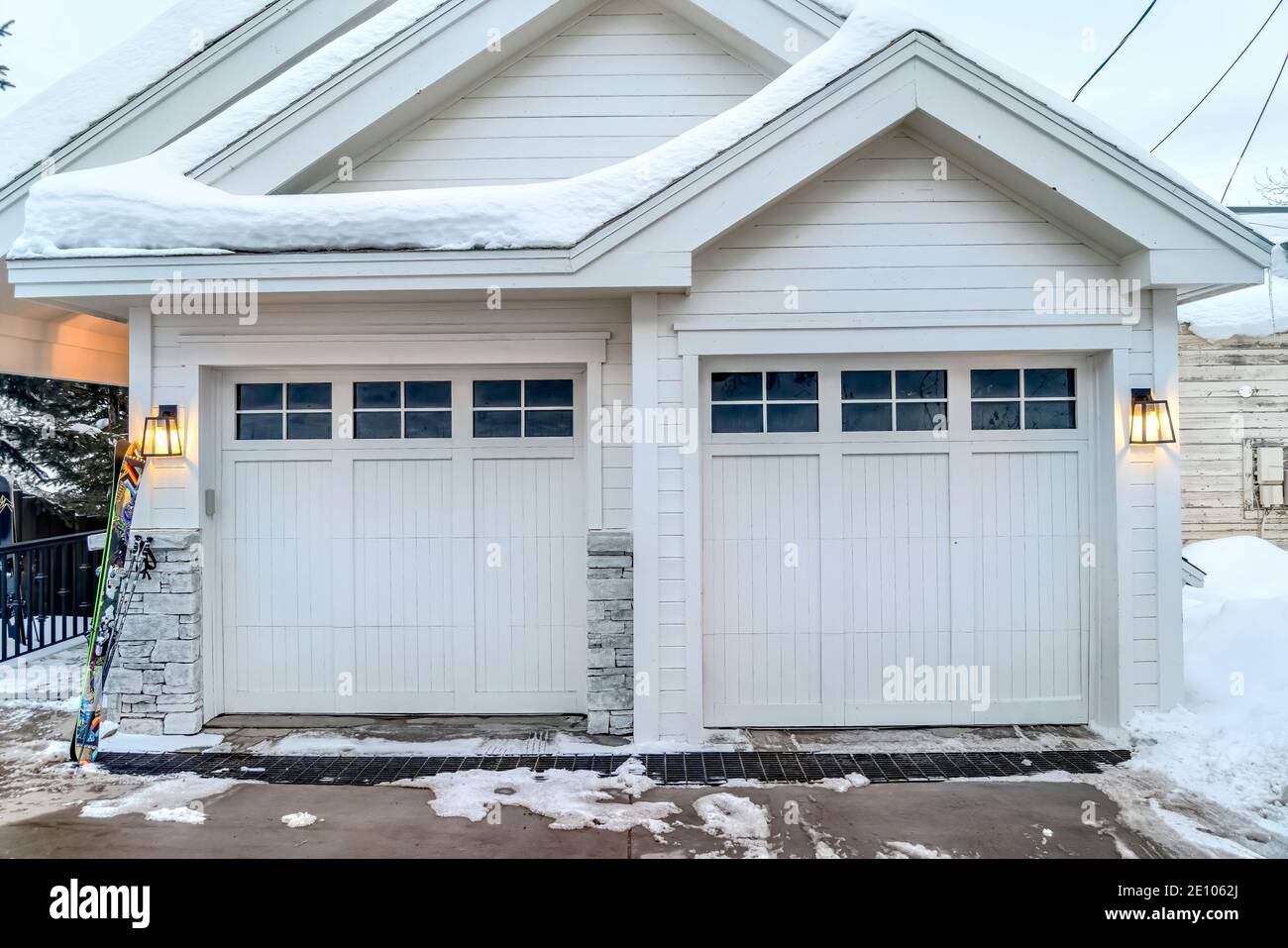Home esterno con pareti bianche tetti a timpano e due vetri porte del garage a pannelli Foto Stock