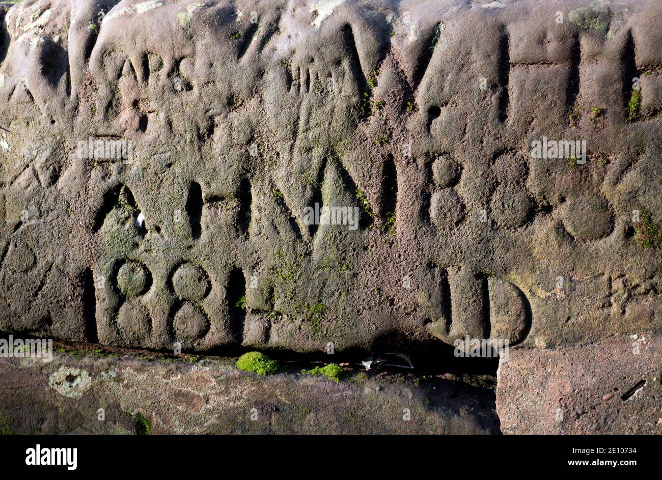 Vecchie date e iniziali scolpite in un muro di arenaria, Warwick, Regno Unito Foto Stock