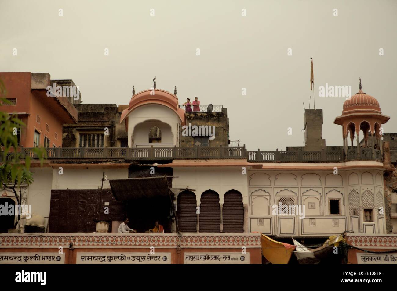 Persone che hanno tempo libero sui balconi nel pomeriggio, su storie residenziali di un edificio costruito in stile architettonico Rajput situato nella zona commerciale di Sireh Deorhi Bazar a Jaipur, Rajasthan, India. Foto Stock