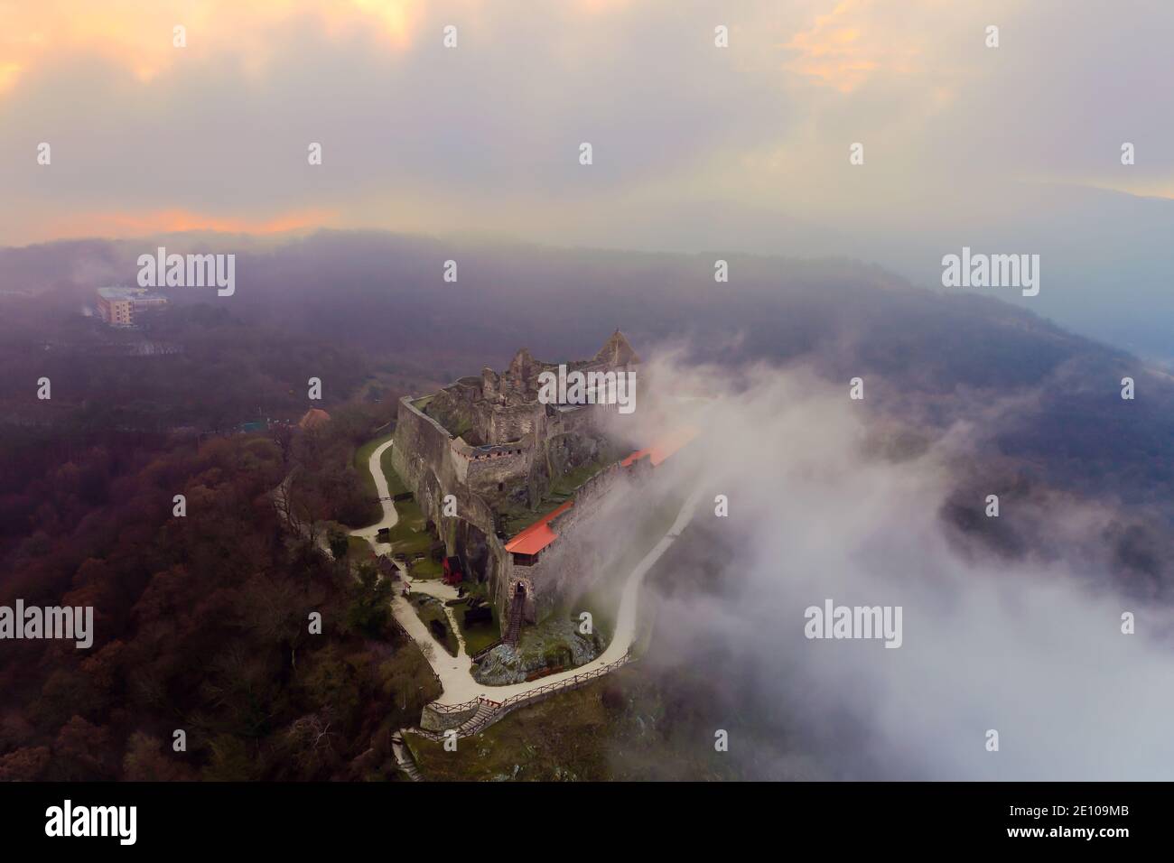 Rovine del castello della cittadella di Visegrad nel Danubio curva Ungheria. Fantastico paesaggio aereo in cattive condizioni atmosferiche. Nebbia, alba nuvolosa Foto Stock