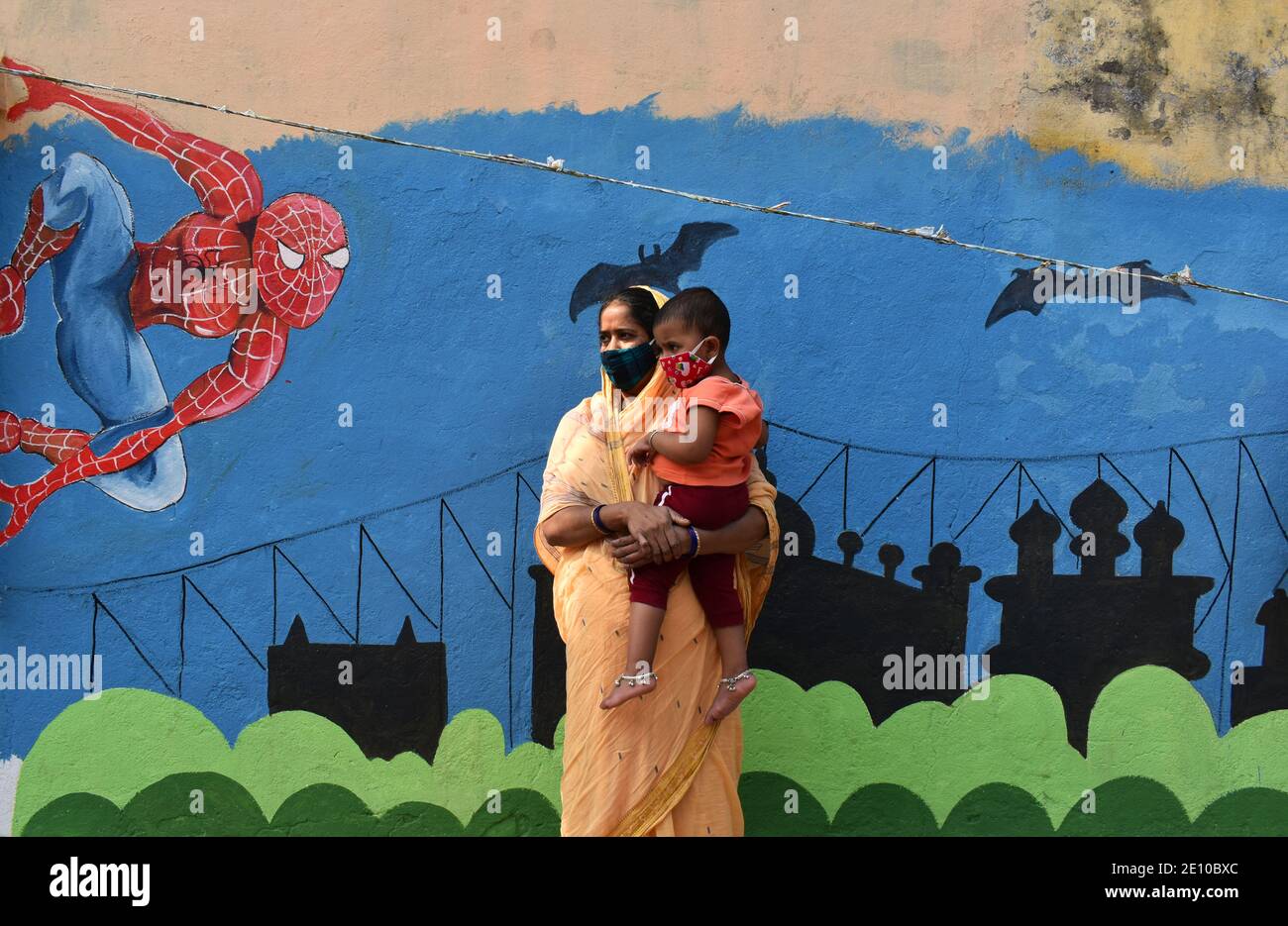 Una donna con il suo bambino che indossa una maschera protettiva in piedi sulla strada tra il risparmiato di Covid-19 a Kolkata. L'India ha aggiunto 18,177 infezioni da coronavirus nelle ultime 24 ore, collocando il suo numero complessivo a 1.03 casi di Crores. Il regolatore indiano dei farmaci la domenica ha approvato Oxford COVID-19 vaccino Covisield, prodotto dal Serum Institute, e ha sviluppato in modo indigeno Covaxin di Bharat Biotech per un uso limitato di emergenza nel paese, aprendo la strada ad un massiccio azionamento di inoculazione. (Foto di Sudipta Das/Pacific Press) Foto Stock