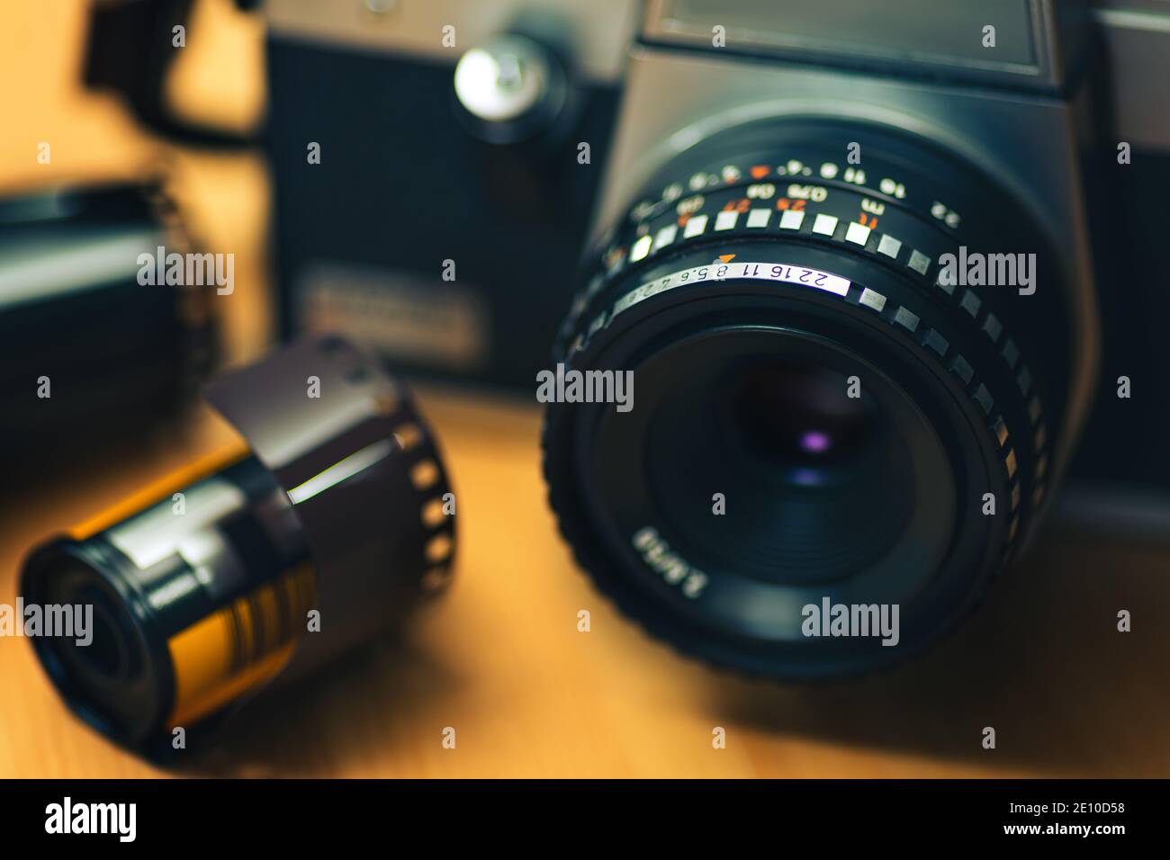 Immagine realistica di una telecamera analogica con una pellicola negativa di 35 mm su sfondo in legno. Foto Stock Immagine realistica di una telecamera analogica con una pellicola negativa di 35 mm su sfondo in legno. Foto Stock