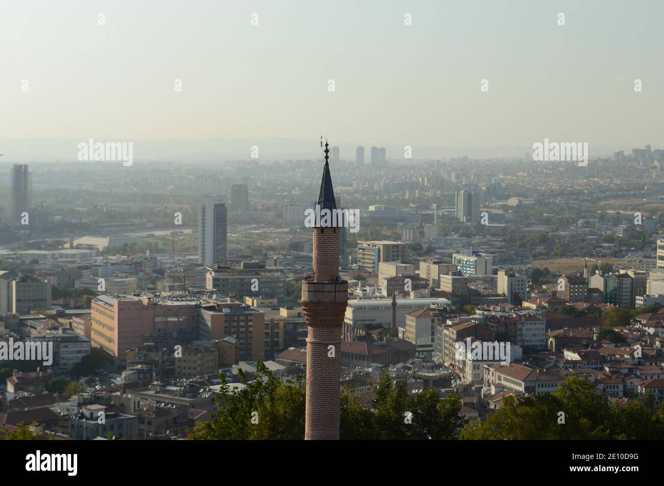 un minareto storico visibile attraverso le case Foto Stock