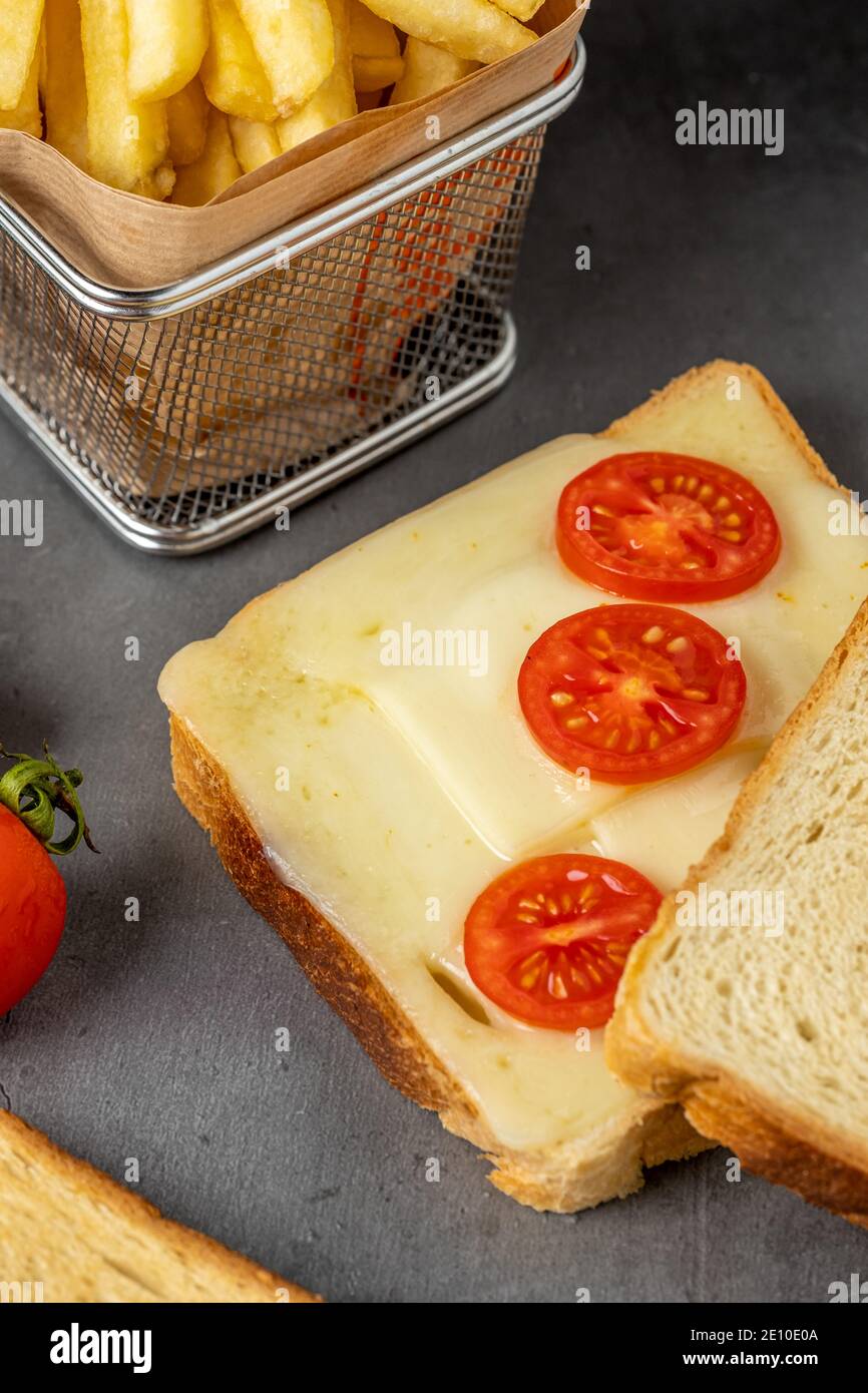 toast fritti con mozzarella e pomodori ciliegini con patatine fritte. Foto Stock