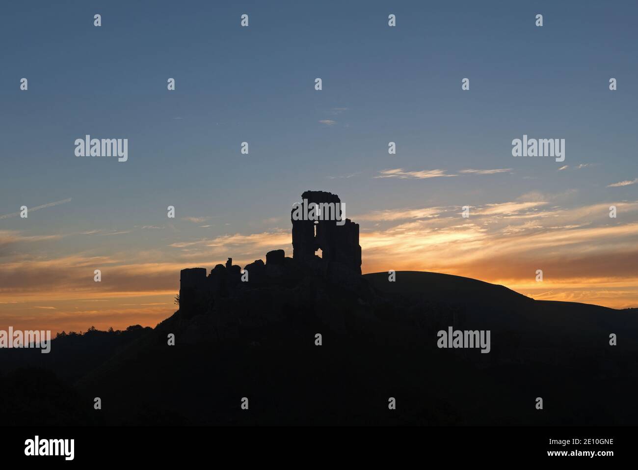 Alba dietro le rovine del castello medievale di Corfe nell'isola di Purbeck, Dorset, Inghilterra, Regno Unito. Foto Stock