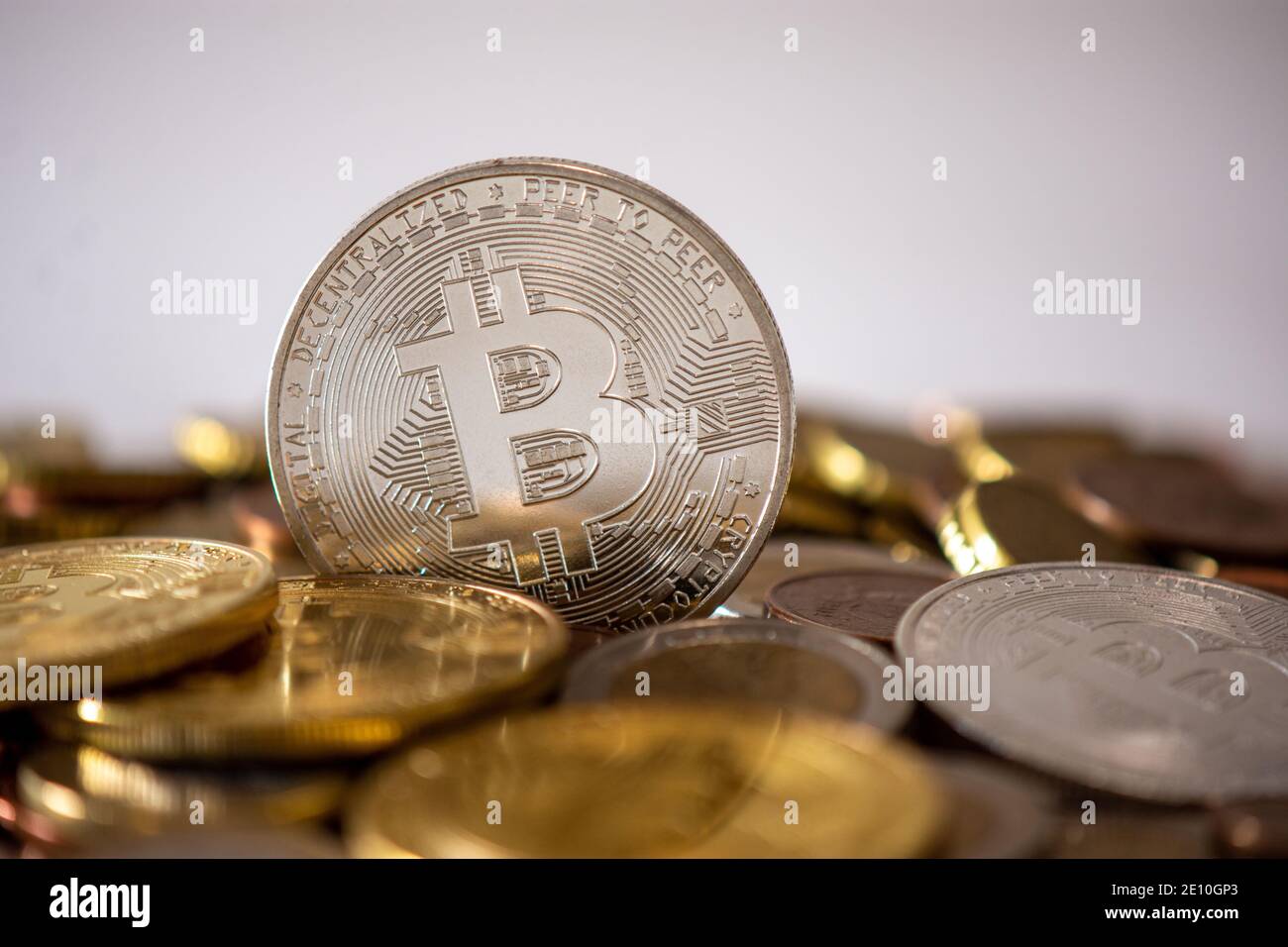 Una moneta d'argento in piedi tra molte monete offuscate. Bitcoin è una criptovaluta, una valuta digitale decentralizzata senza una banca centrale Foto Stock