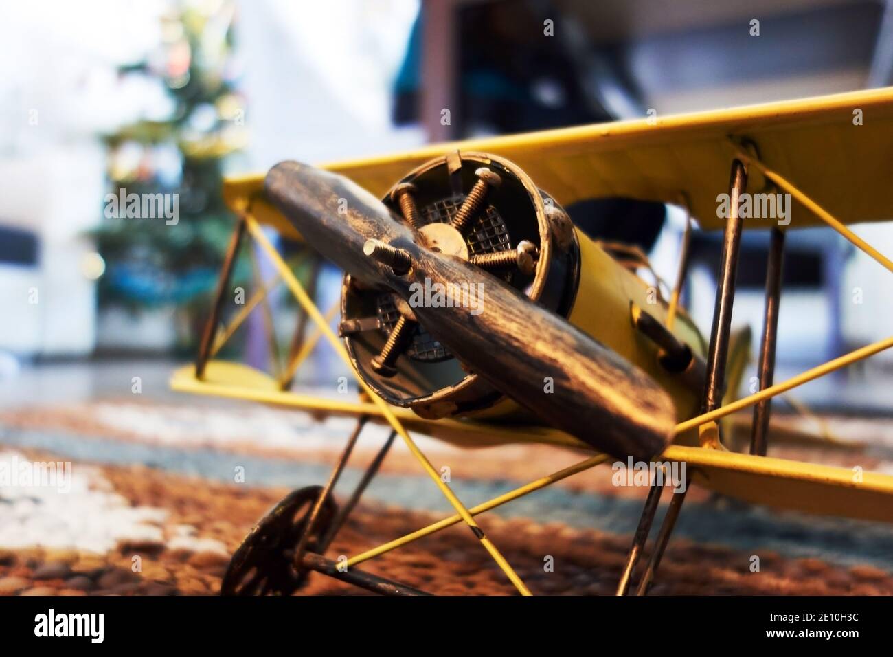 primo piano di un biplano giallo in miniatura che simboleggia il sogno di volare e viaggiando durante la pandemia del coronavirus Foto Stock