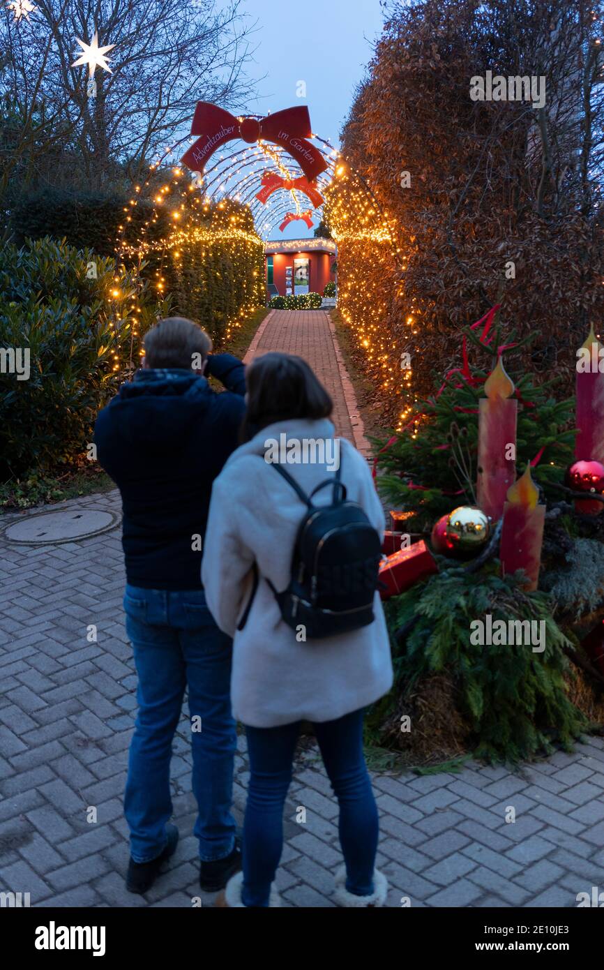 Una coppia che fotografa le luci e le decorazioni natalizie a Kittenberger Erlebnisgärten, una popolare destinazione turistica in Austria Foto Stock