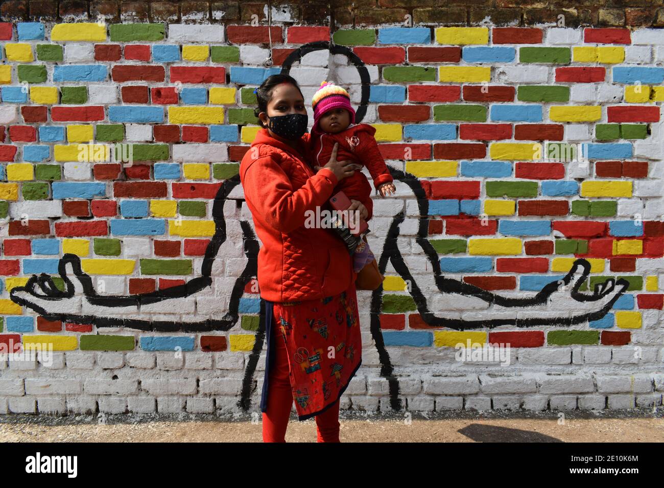 Kolkata, India. 3 gennaio 2021. (1/3/2021) UNA donna con il suo bambino che indossa una maschera protettiva in piedi sulla strada in mezzo alla pandemia di Covid-19 a Kolkata. L'India ha aggiunto 18,177 infezioni da coronavirus nelle ultime 24 ore. Il regolatore indiano dei farmaci la domenica ha approvato Oxford COVID-19 vaccino Covisield, prodotto dal Serum Institute, e ha sviluppato in modo indigeno Covaxin di Bharat Biotech per un uso limitato di emergenza nel paese, aprendo la strada ad un massiccio azionamento di inoculazione. (Foto di Sudipta Das/Pacific Press/Sipa USA) Credit: Sipa USA/Alamy Live News Foto Stock