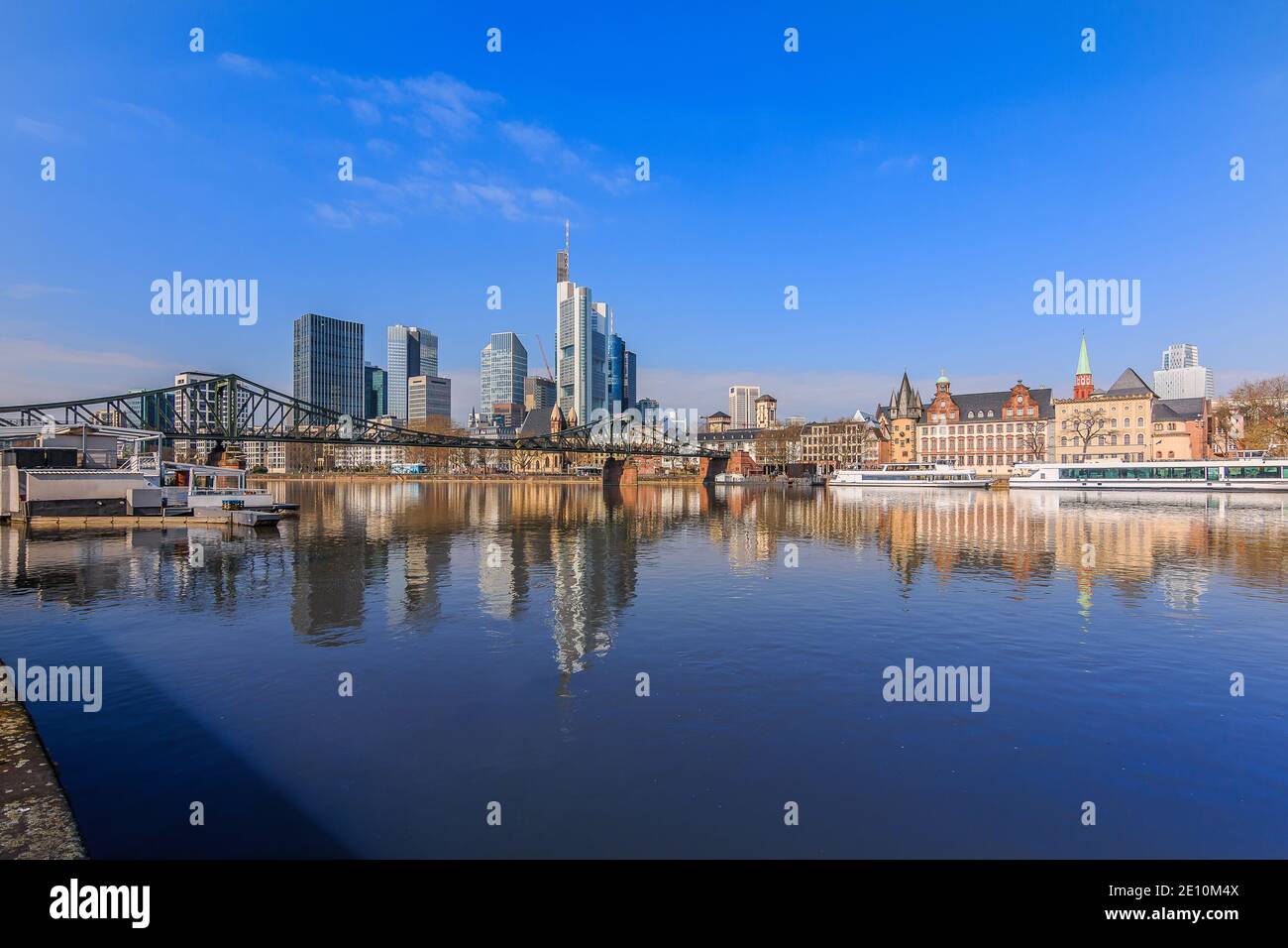 Quartiere finanziario di Francoforte al sole. Skyline edifici commerciali e ponte sul fiume Main con riflessi. Navi in ormeggio Foto Stock