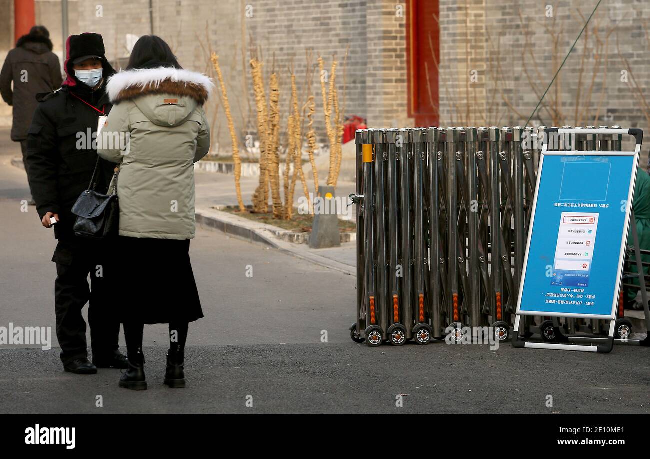 Pechino, Cina. 3 gennaio 2021. Una guardia controlla l'app per la salute di una donna e la sua temperatura prima di consentirle di entrare in una strada laterale recentemente chiusa a Pechino domenica 1 gennaio 2021. La capitale cinese ha bloccato parte della città, comprese le strade di chiusura, le chiese e le scuole, nella sua lotta contro una potenziale epidemia di coronavirus. Foto di Stephen Shaver/UPI Credit: UPI/Alamy Live News Foto Stock