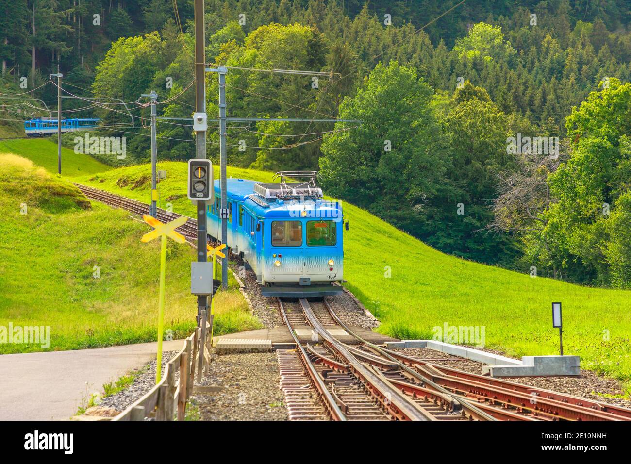 Rigi kulm, Svizzera - 25 agosto 2020: Un treno turistico blu viaggia sulla ferrovia a cremagliera attraverso verdi prati erbosi sul Monte Rigi. Foto Stock