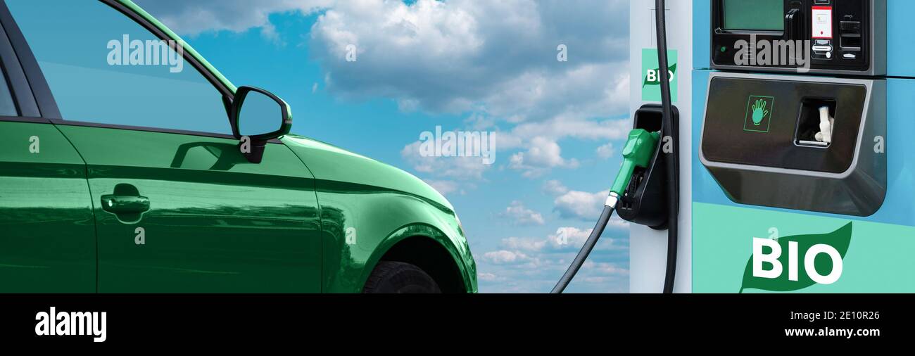 Stazione di rifornimento biocarburante con auto verde su uno sfondo di cielo blu. Foto Stock