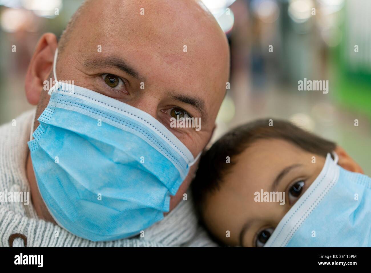 padre e figlio con maschere protettive a casa, proteggere l'infezione da coronavirus covid-19 sul tavolo, il nuovo concetto di distanza sociale normale. primo piano Foto Stock