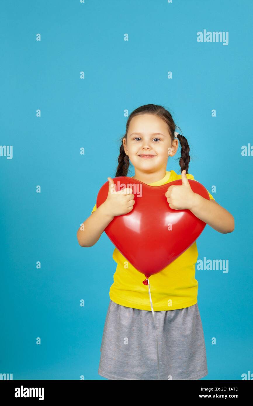 Ragazza adolescente con amore regalo romantico, innamorato. Vendita di San  Valentino. Ritratto di bambino con palloncino cuore isolato su sfondo blu  studio Foto stock - Alamy