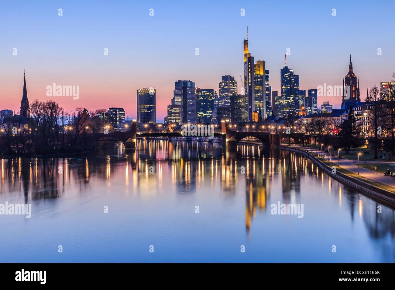 Skyline di Francoforte in serata. Tramonto all'ora blu con grattacieli illuminati dal quartiere finanziario e degli affari. Riflessioni sul fiume Foto Stock