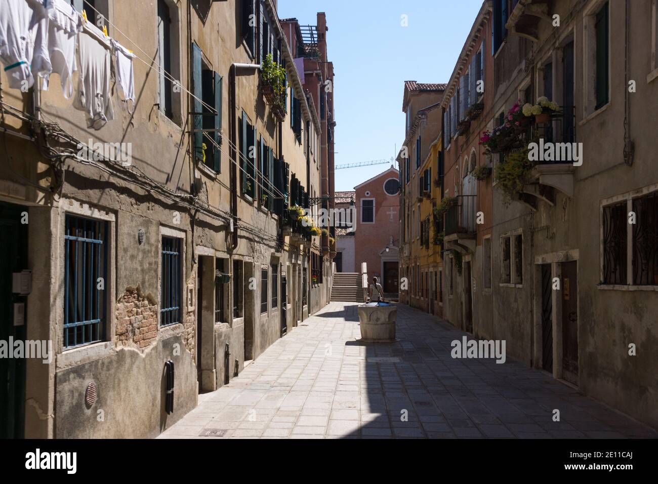 Un turista solitaria che cammina lungo la Ruga Vecchia - un esempio di come le strade secondarie e laterali deserte di Venezia sono quando sei fuori dai sentieri battuti. Italia Foto Stock