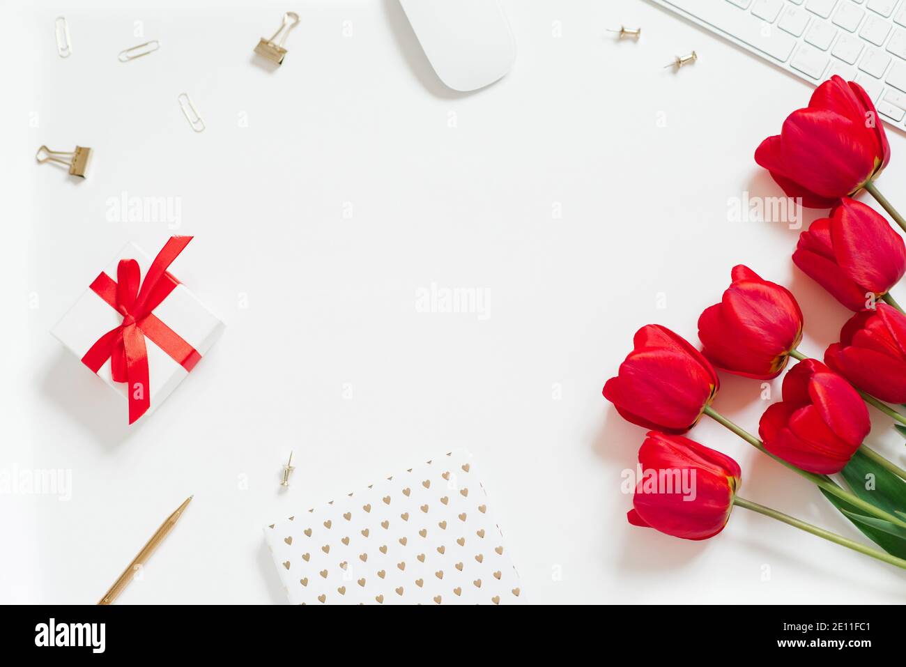 Flat Lay Valentines Day sfondo con tastiera per computer, regalo, tazza da caffè e tulipano rosso vista dall'alto spazio copia bianco. Sfondo per un blogger o offic Foto Stock