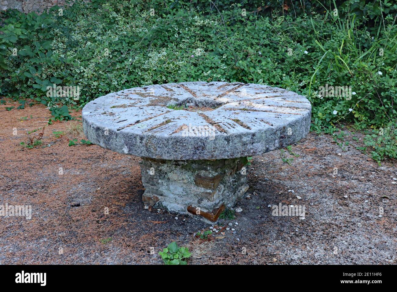 Un tavolo da picnic circolare a piedistallo fatto di mattoni in un piccolo parco pubblico nella città di Colyton in Devon. Foto Stock
