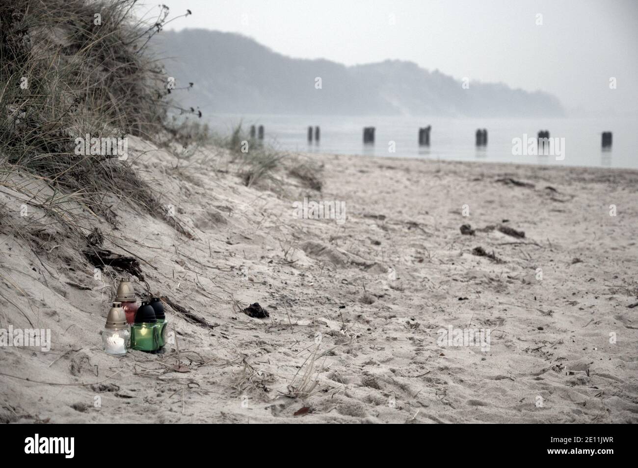 Tre grandi candele bianche di paraffina bruciano sul mare di sfondo della  spiaggia di sabbia