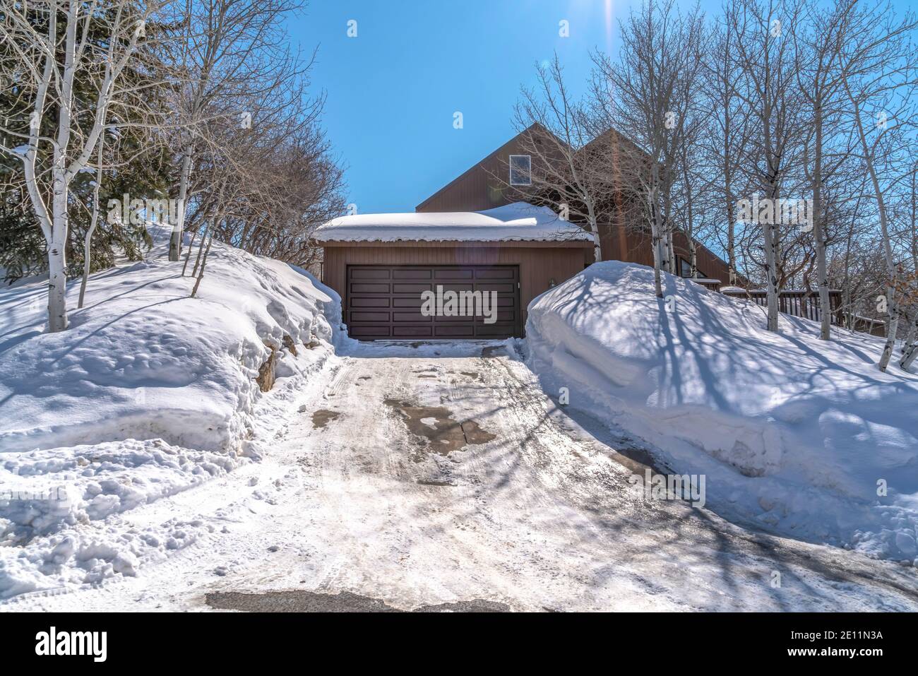 Casa di montagna a Park City Utah con vialetto nevoso che conduce alla porta grigia del garage Foto Stock