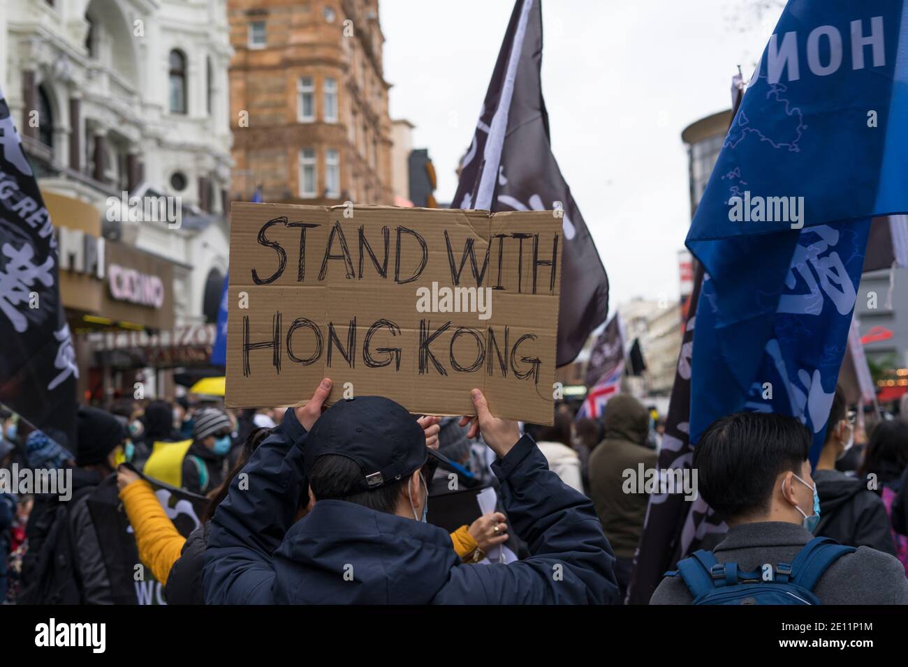 Sostare con Hong Kong pro democrazia protesta in Leicester Square. Uomo che tiene in mano il cartello di cartone. Londra Foto Stock