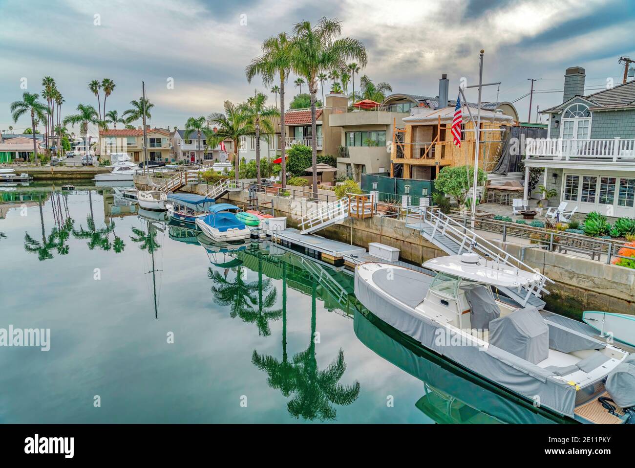 Barche sul canale con riflesso di palme che costeggiano il Strade di Long Beach Foto Stock