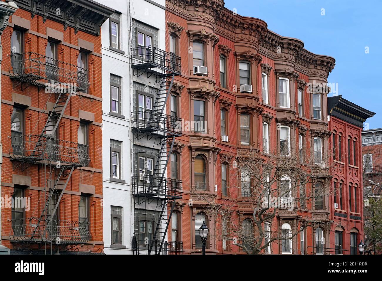 Vecchi edifici di appartamenti a New York con cornicione ornato e scala esterna di fuga antincendio Foto Stock