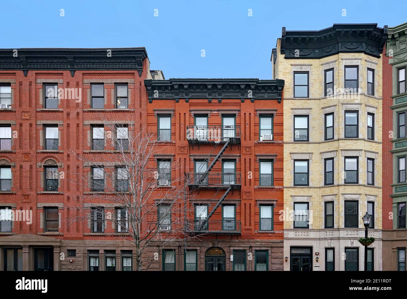 Vecchi edifici di appartamenti a New York con cornicione ornato e scala esterna di fuga antincendio Foto Stock
