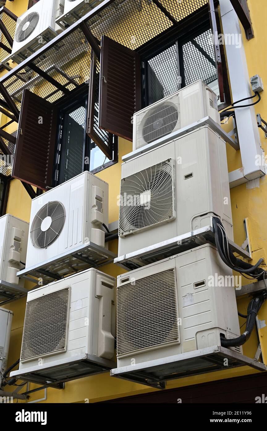 Sul retro sono generalmente visibili più unità di climatizzazione Di un edificio nel sud-est asiatico a causa del caldo tempo e umidità nei tropici Foto Stock