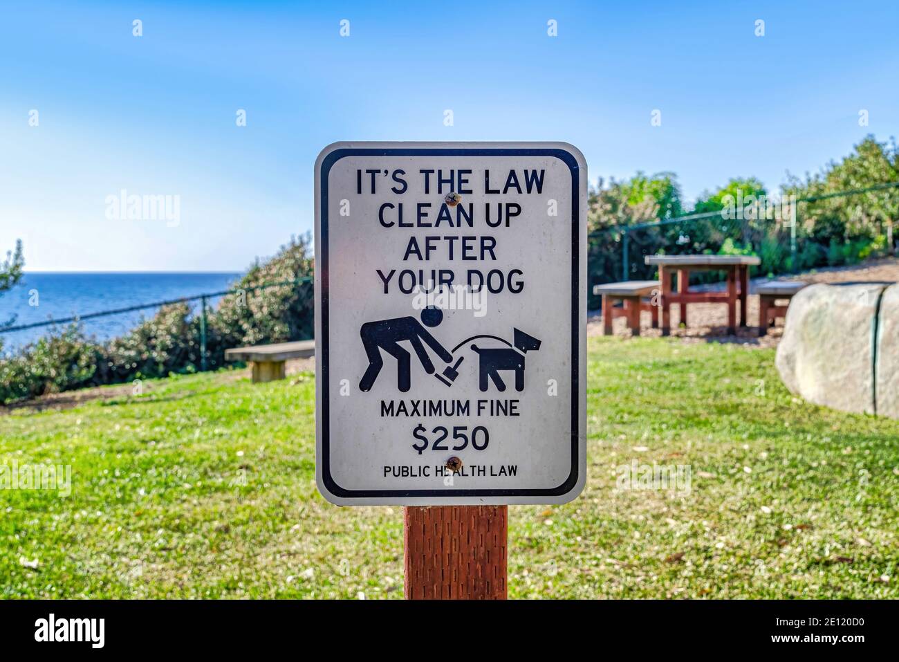 Pulire dopo il vostro segno del cane contro l'erba verde e. Cielo a San Diego, California Foto Stock