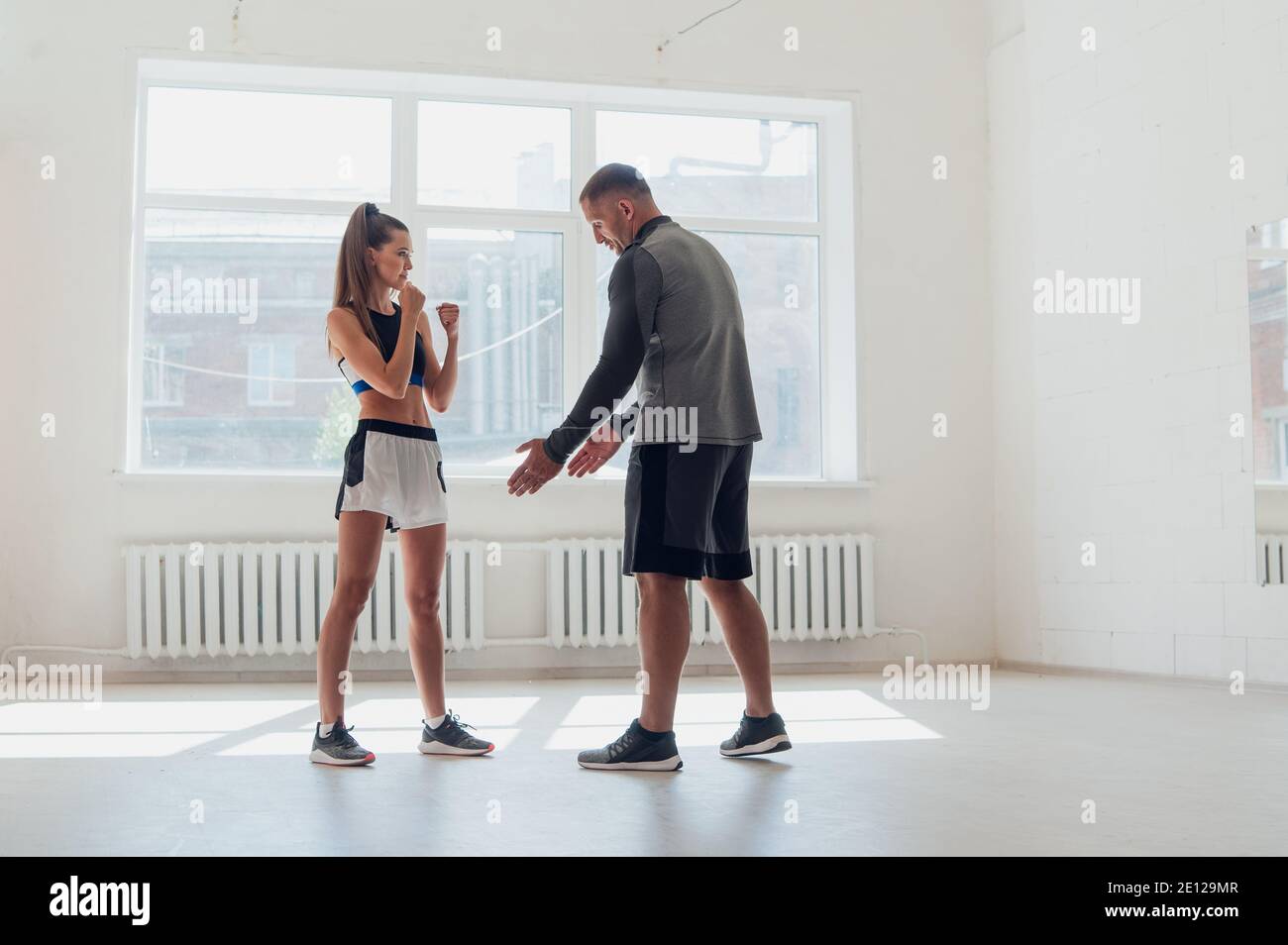 Una giovane vettura attraente di boxing prepara una ragazza graziosa per concorrenza Foto Stock