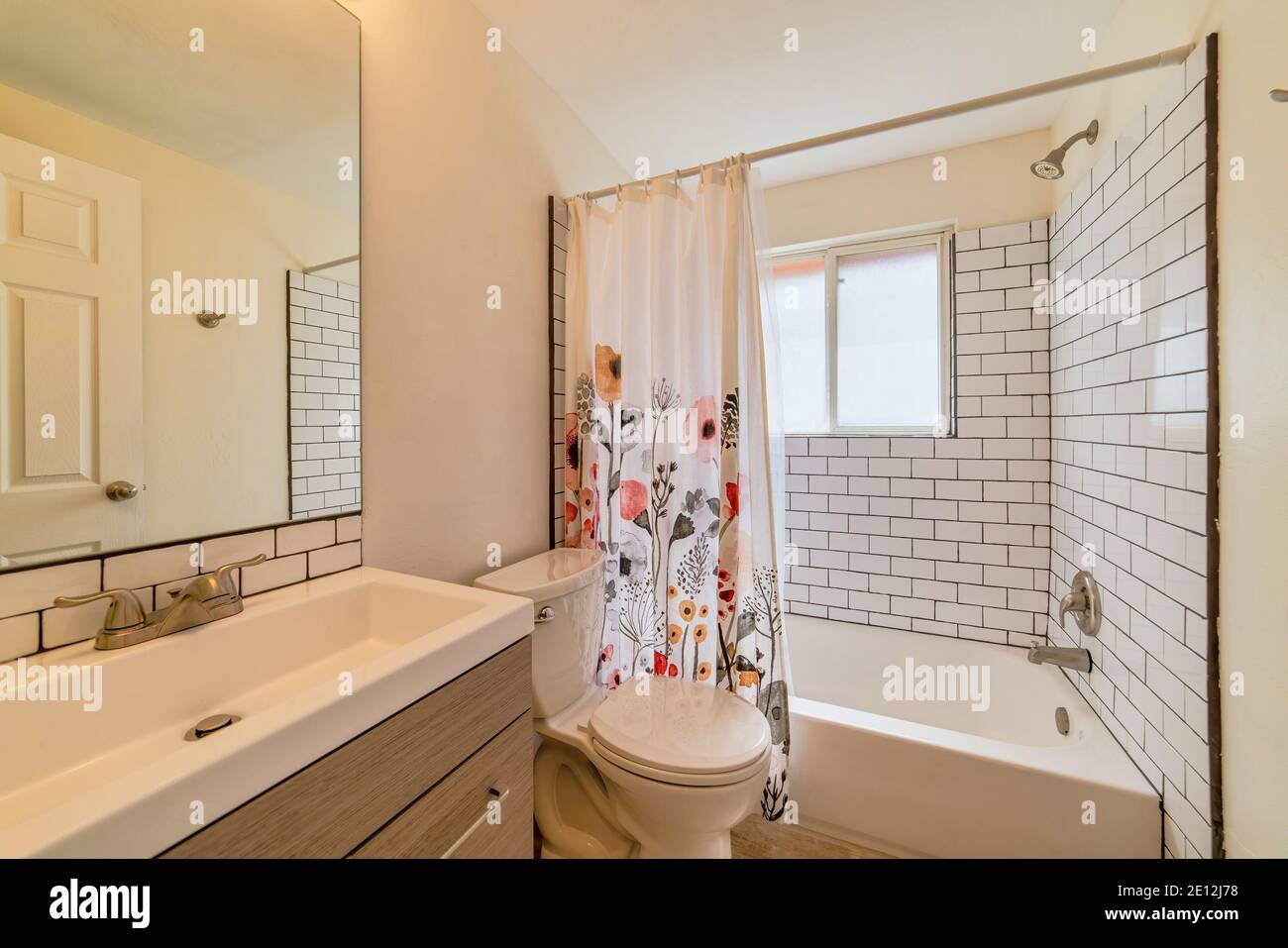 Lavandino e vasca da bagno a muro con tenda per doccia floreale bagno  interno Foto stock - Alamy
