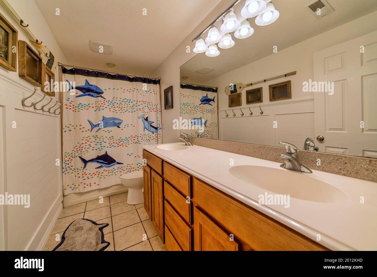 Interno del bagno con graziosa tenda doccia con la stampa dei delfini nelle vicinanze il wc Foto Stock