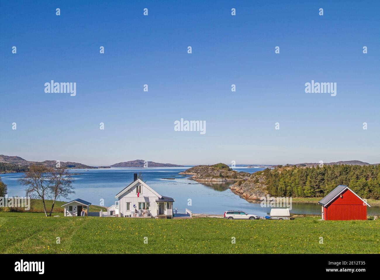 Tipiche case norvegesi sono idillicamente situate su Arnoyfjorden Foto Stock