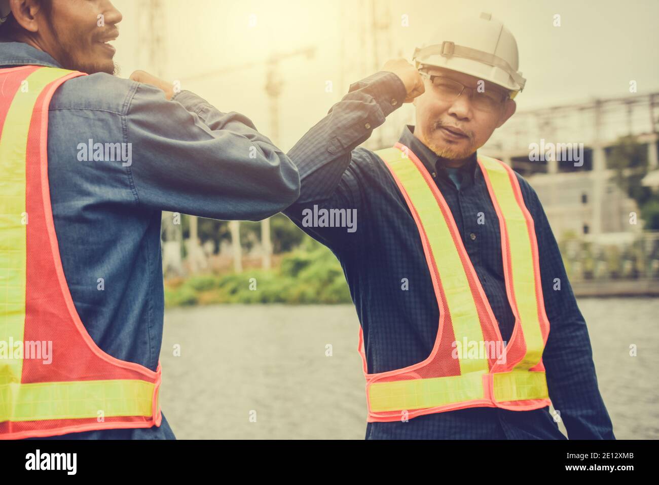 Due persone nuovo normale Ciao non Shake mano Social distanziamento, ingegnere shake mano no touch prevenire il virus Corona Foto Stock