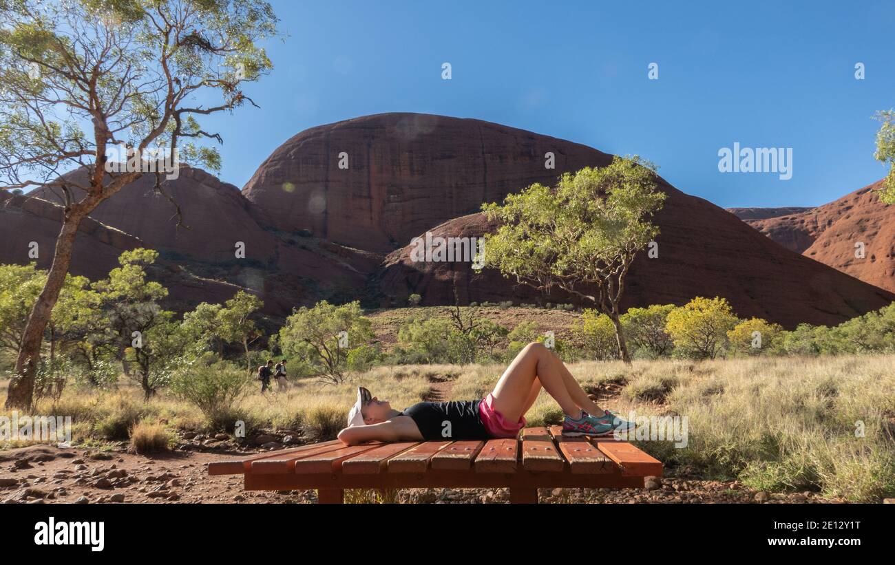 Un turista riposa dopo il trekking attraverso Kata Tjuta l'Olgas, territorio del Nord, Australia. Foto Stock