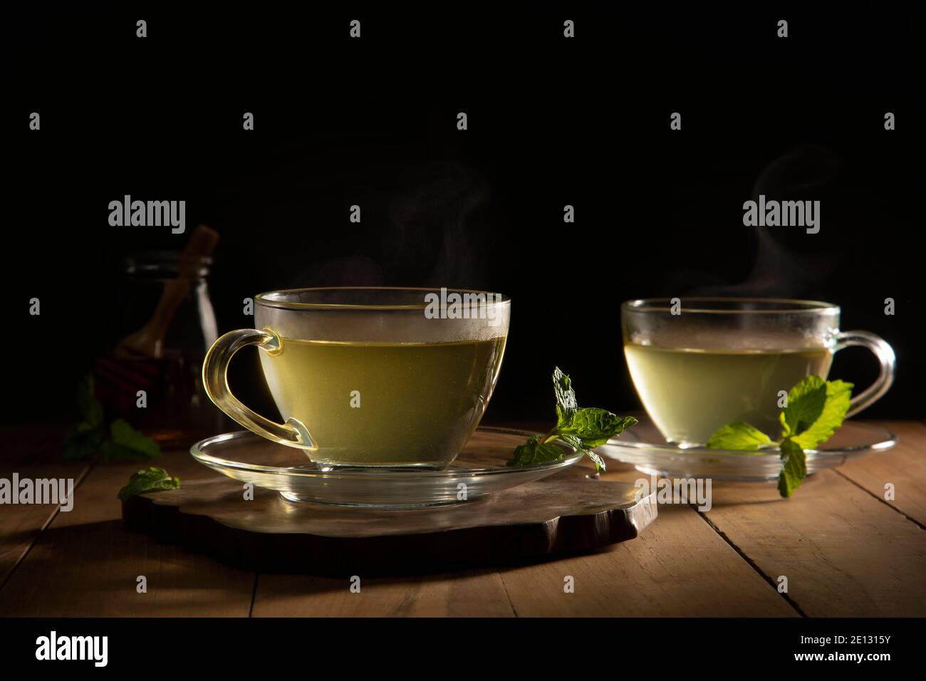 tè verde con foglie di menta su tavolo di legno Foto Stock