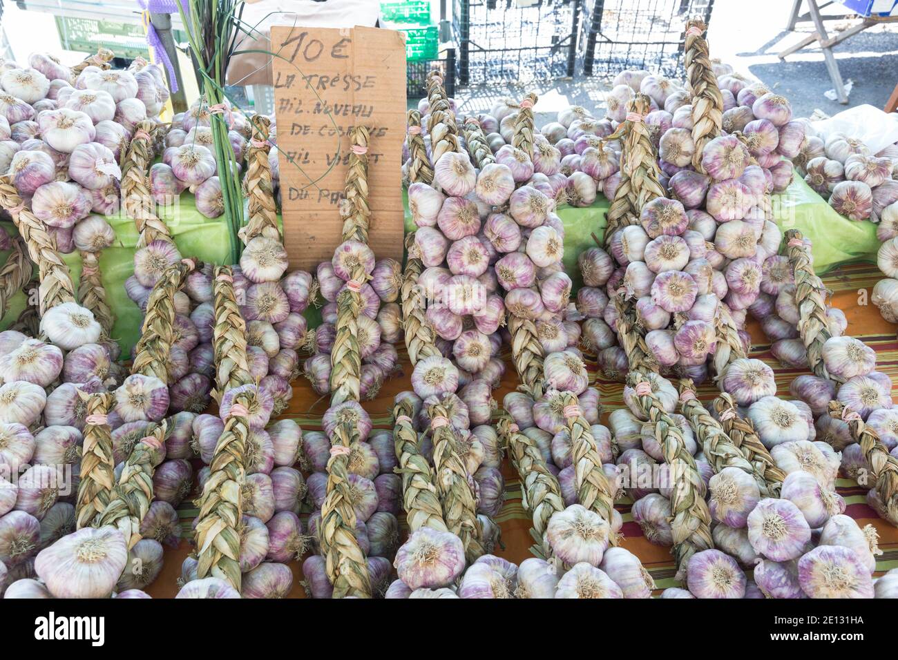 Arles, Provenza, Francia: Trecce di aglio in vendita al mercato all'aperto Foto Stock