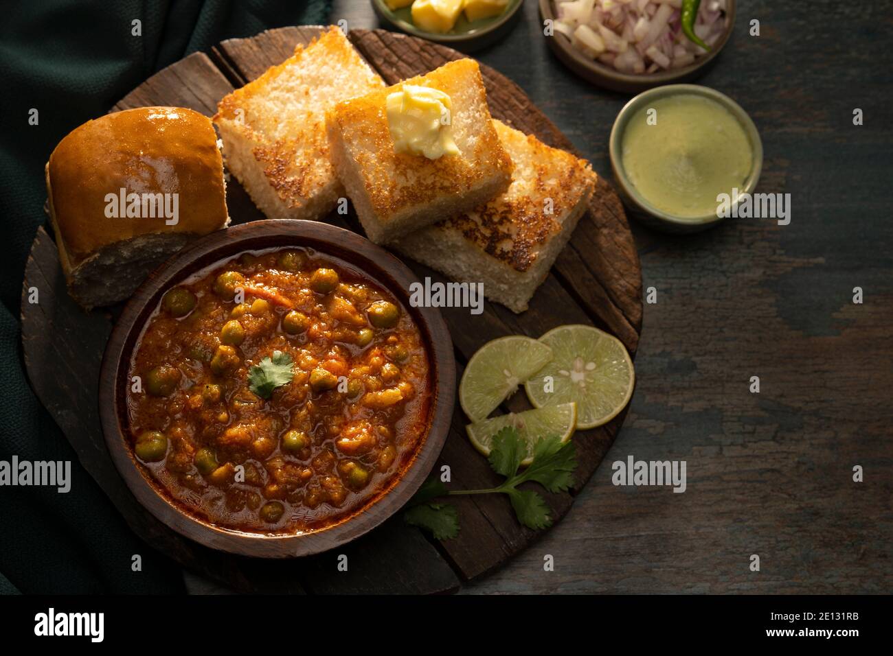 DELIZIOSO PAV BHAJI SERVITO CON ANTIPASTI SU UN VASSOIO DI LEGNO Foto Stock