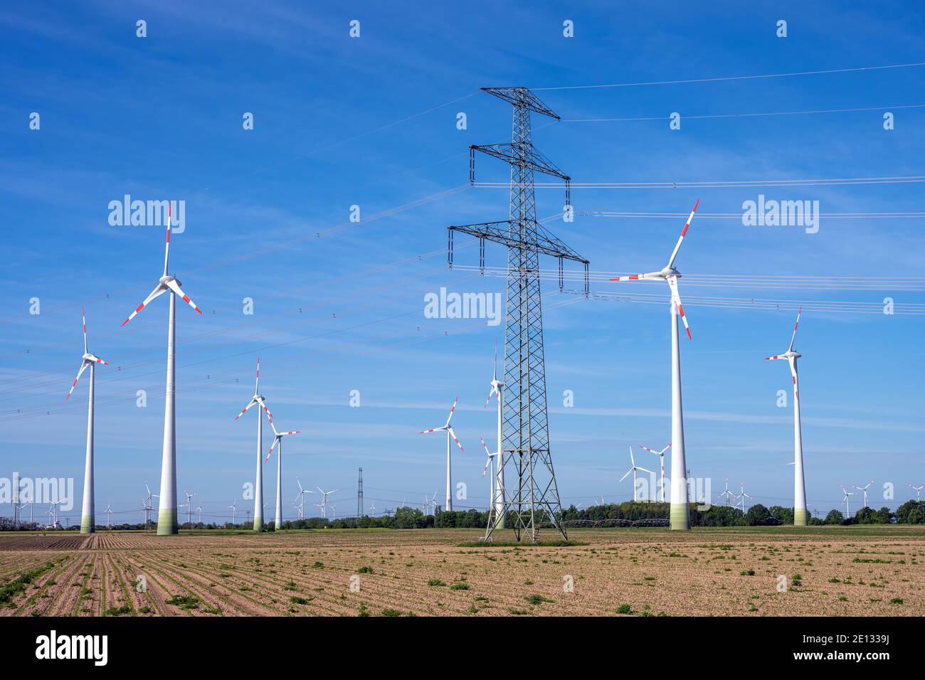 Pilone elettrico e turbine eoliche visto in Germania Foto Stock