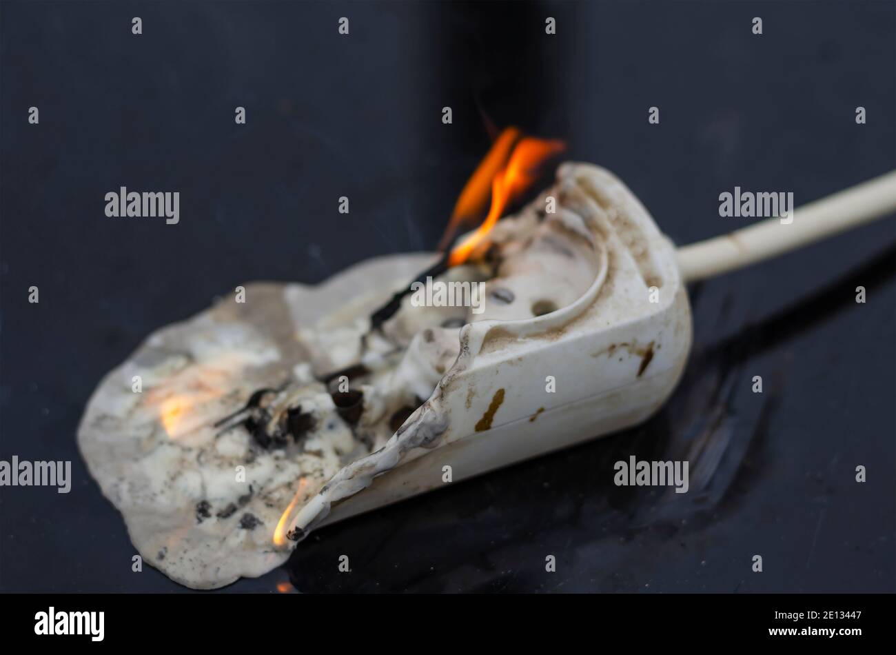 Concetto di sicurezza antincendio ed elettrica. Incendio del cablaggio elettrico. Basetta di alimentazione bruciata per le prese elettriche Foto Stock
