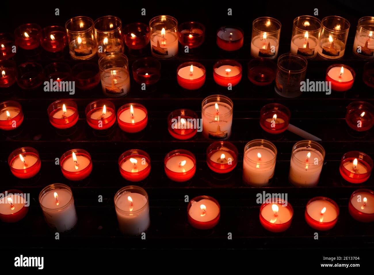 Visualizzazione di candele votive o candele di preghiera illuminate come Cristiano O offerte religiose sull'Alter della Basilica di San Sernin Tolosa Francia Foto Stock